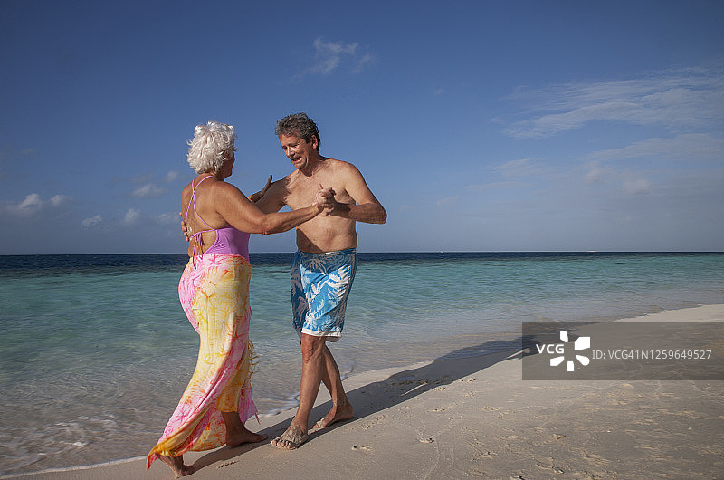 老年夫妇在沙滩上跳舞图片素材