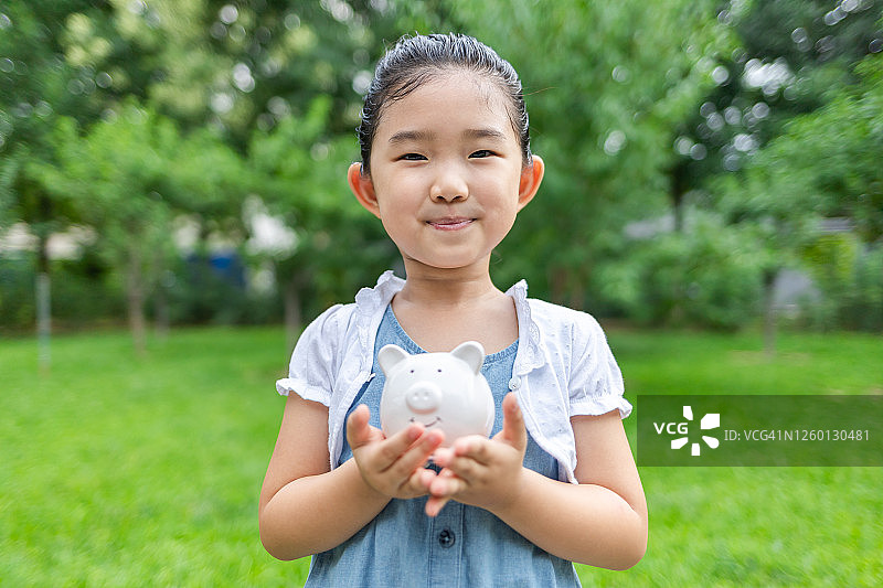 可爱小女孩手持存钱罐图片素材