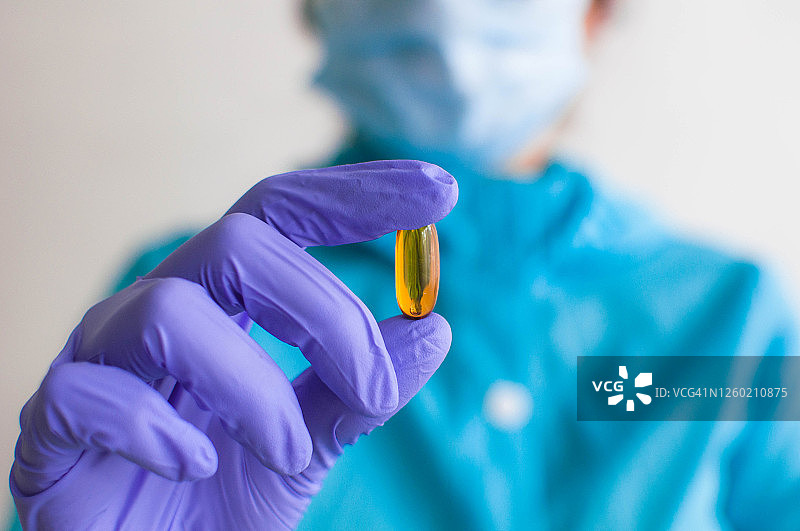 医护人员手持一个药用胶囊图片素材