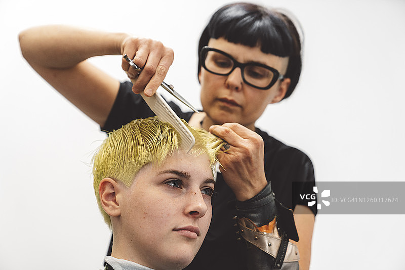 发型师用梳子梳理金色短发图片素材