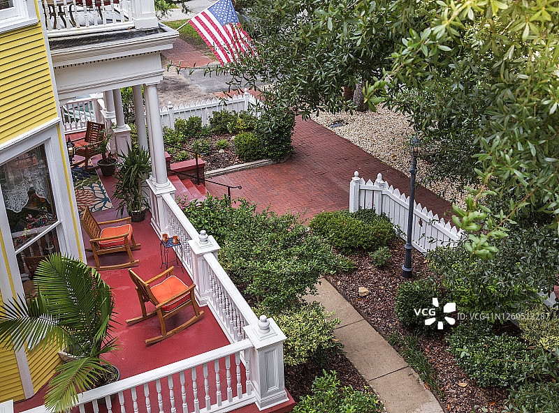 夏季黄色房屋的前廊，有美国国旗，高角度拍摄图片素材