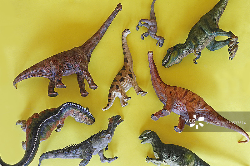 黄色背景上的玩具恐龙图片素材