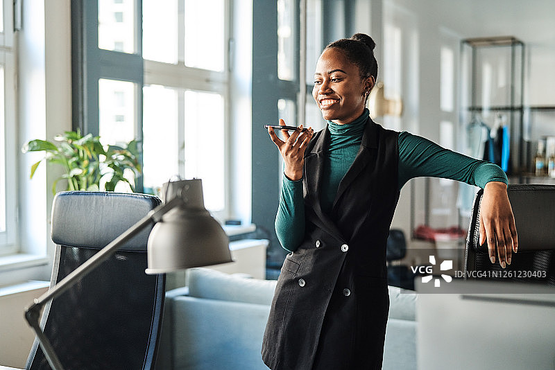年轻女商人在办公室使用智能手机图片素材
