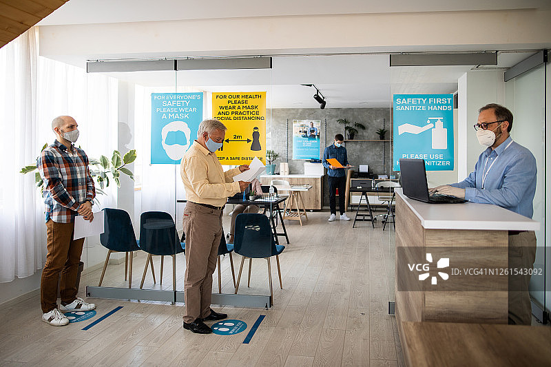 客户在银行柜台前保持社交距离图片素材