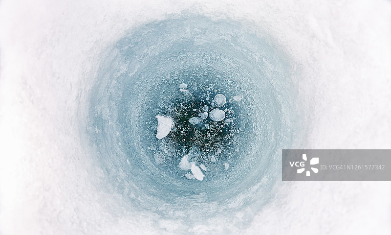 瑞典西博滕省冰冻湖面上冰钓孔的特写图片素材