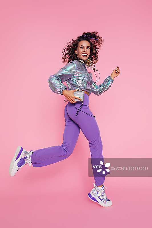 手持老式播放器跳舞的快乐女孩图片素材