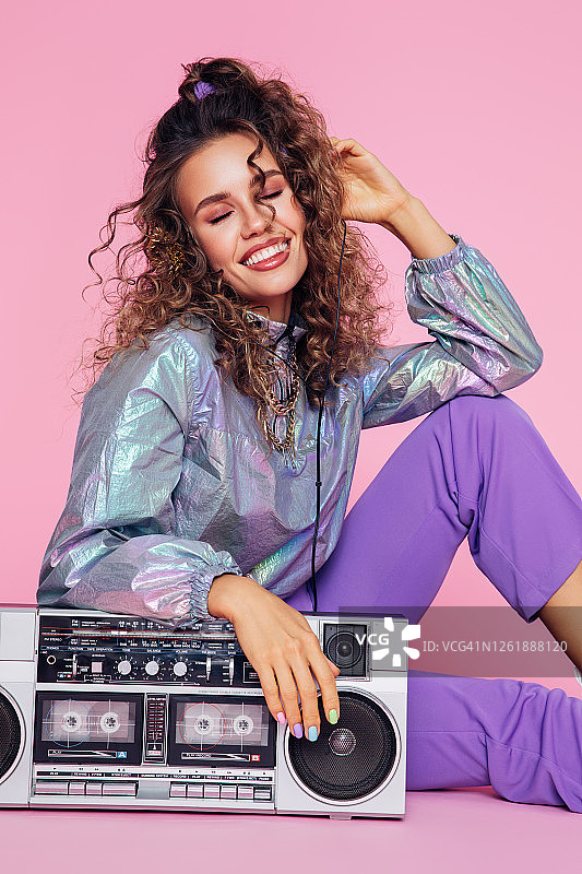 拿着卡式录音机的时髦女孩的画像图片素材