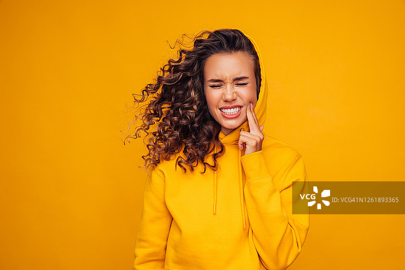 身穿黄色毛衣牙疼的漂亮女孩图片素材