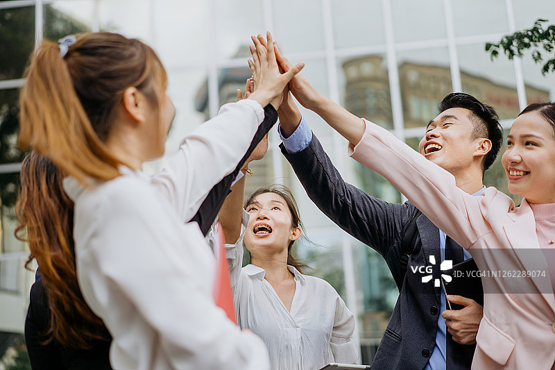 举起手臂击掌的快乐商务人士图片素材