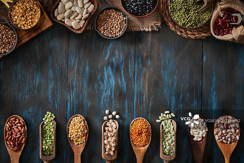 各种干豆在蓝色木桌上构成框架的俯视低调照片图片素材