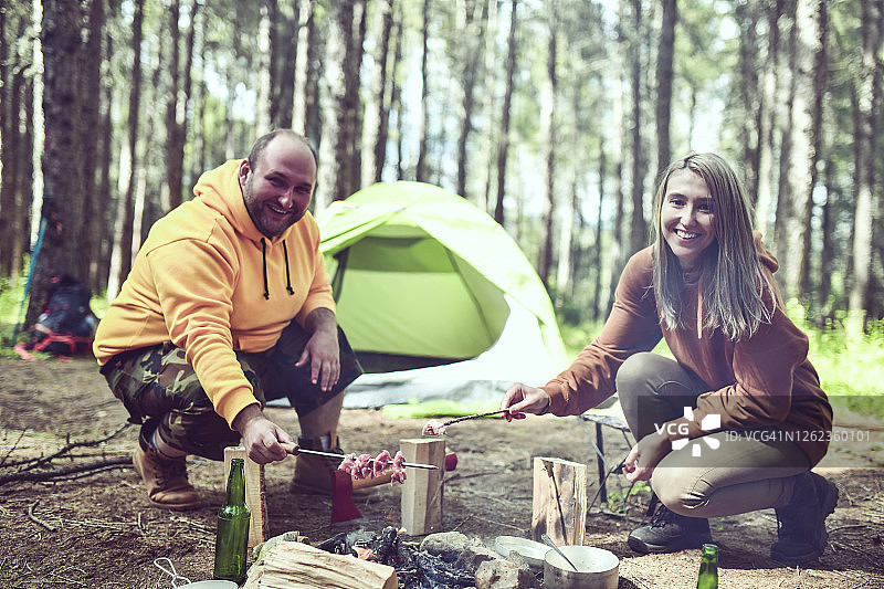 在森林里烧烤的秃顶男人和他的女友图片素材