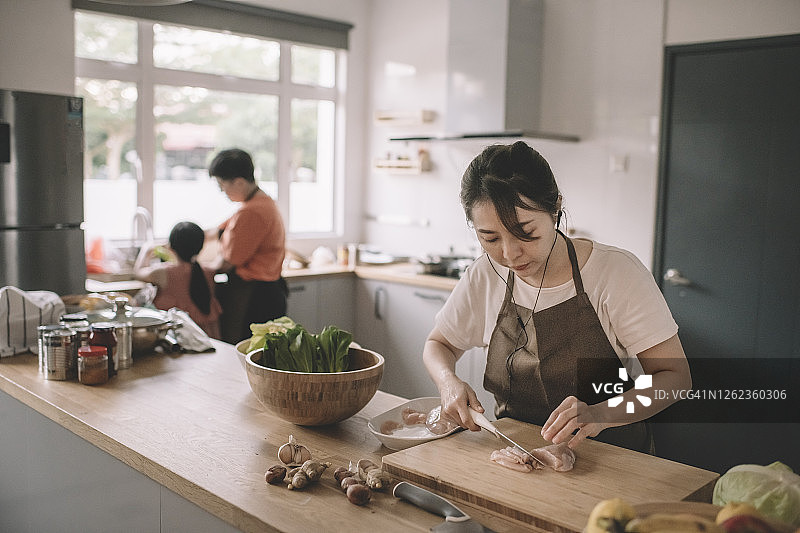 中国母亲和家人在厨房准备食物图片素材