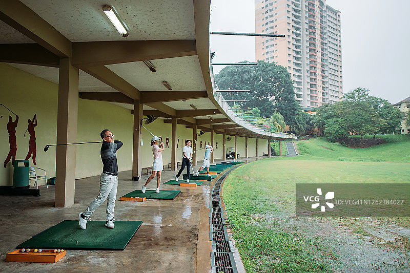 亚洲高尔夫球手在练习场挥杆图片素材