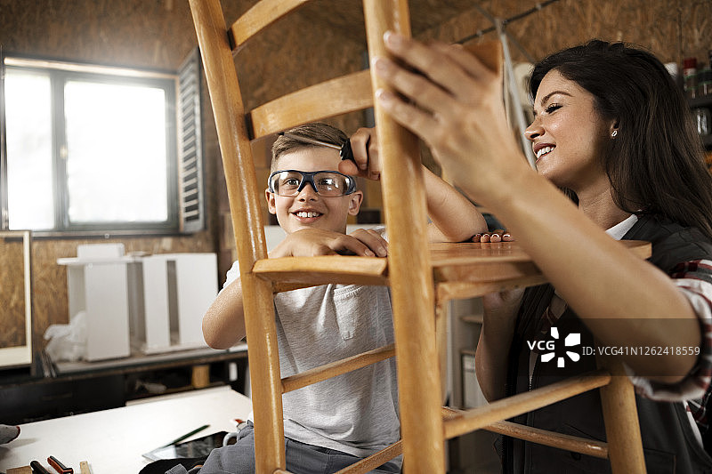 年轻的母亲和儿子在工作室一起工作图片素材