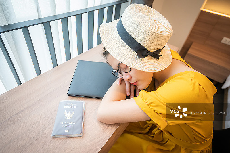 在机场候机时趴在桌子上睡觉的年轻泰国女人图片素材