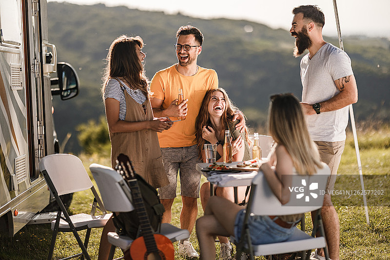在野外露营时聊天的快乐朋友们图片素材
