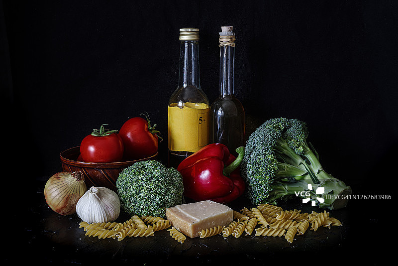 静物：番茄、西兰花、油和意大利面，黑色背景图片素材