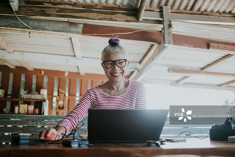 使用电脑在家工作的泰国摄影师图片素材