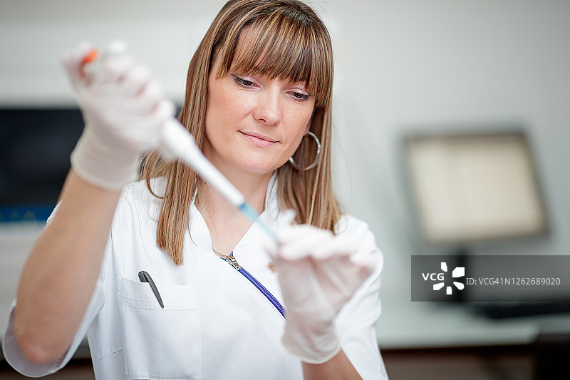 年轻女子在实验室用移液管取样图片素材