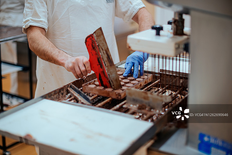 用刮刀从模具中去除多余的巧克力图片素材