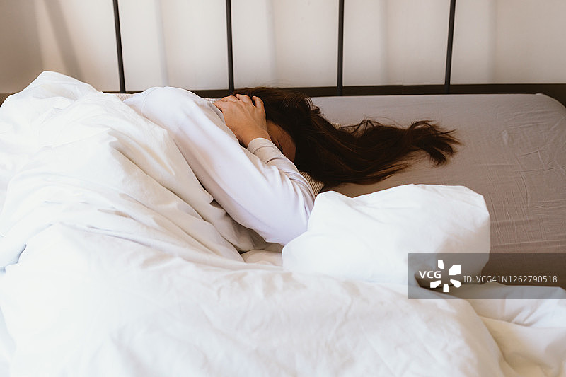 因噪音难以入睡，用手捂住耳朵的女人图片素材