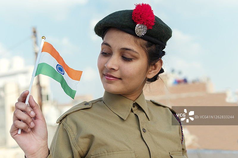 印度独立日：身穿印度少年团制服的女孩手持印度国旗图片素材