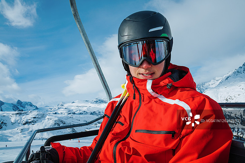 在瑞士采尔马特滑雪胜地乘坐滑雪缆车的年轻滑雪者图片素材