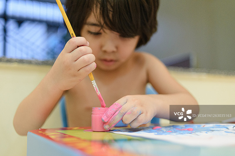 喜欢用颜料、刷子和手绘画的亚洲儿童图片素材