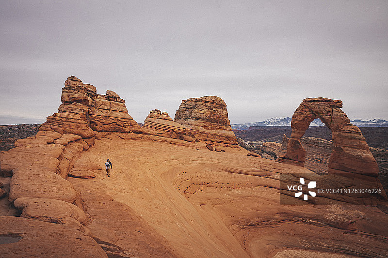 男人和孩子站在拱门国家公园的精致拱门附近图片素材