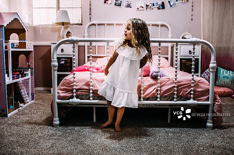 年轻女孩站在床尾看向远方图片素材