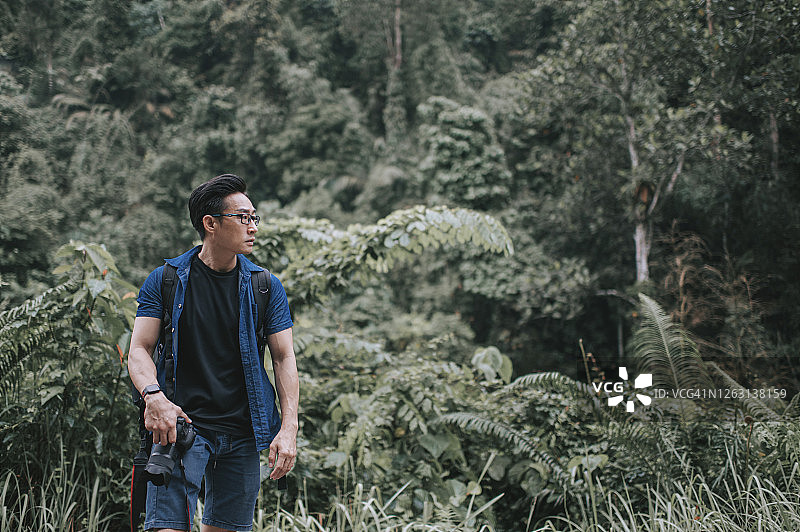 中国中年男子周末携带单反相机去徒步旅行图片素材
