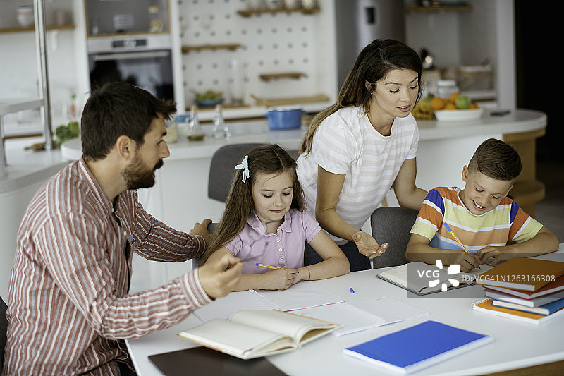 父母和女儿、儿子在家一起做作业图片素材