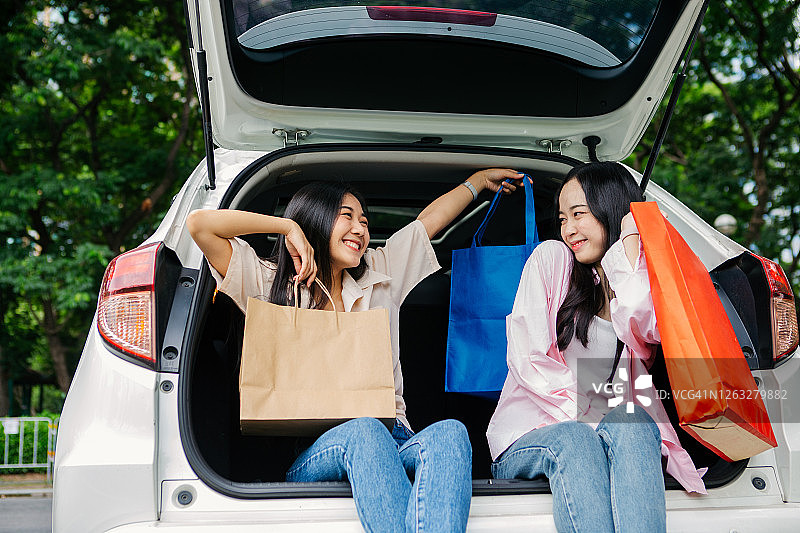 两位快乐的亚洲女性朋友在两厢车中享受公路旅行图片素材