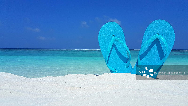 沙滩上的蓝色人字拖图片素材