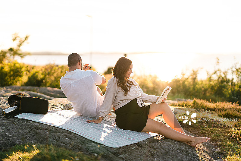 女人和男友在野餐时读书图片素材