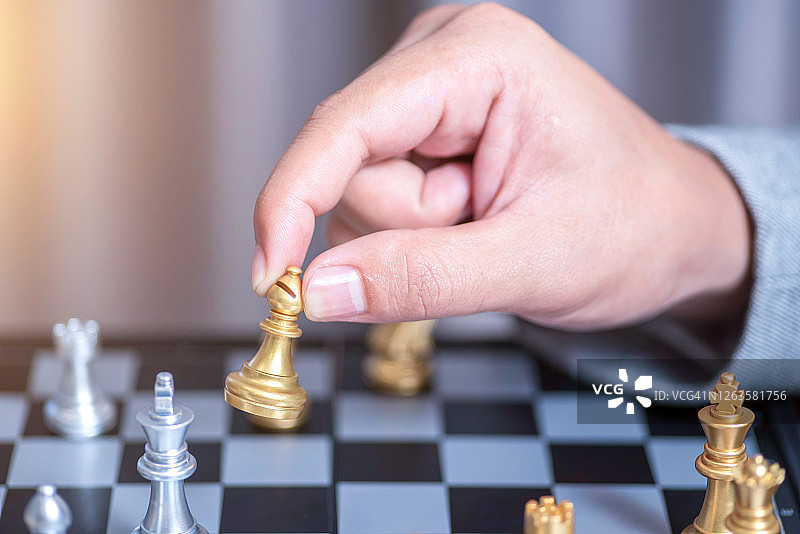 商务人士手持国际象棋，目标明确图片素材