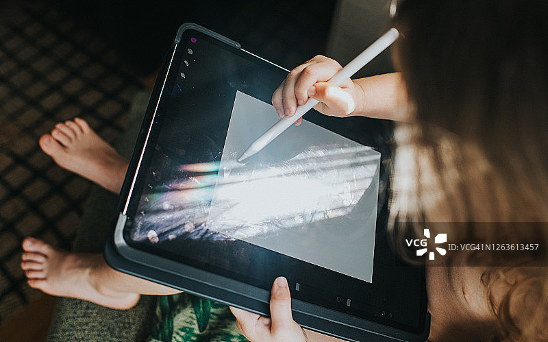 儿童在平板设备上使用电子笔图片素材