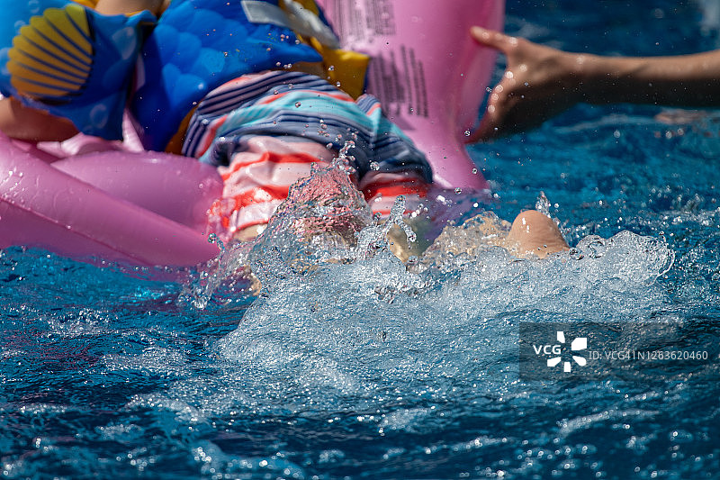 男孩在游泳池里游泳图片素材