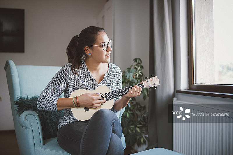 在家弹尤克里里的女人图片素材