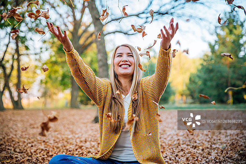 女人在空中抛洒秋叶图片素材