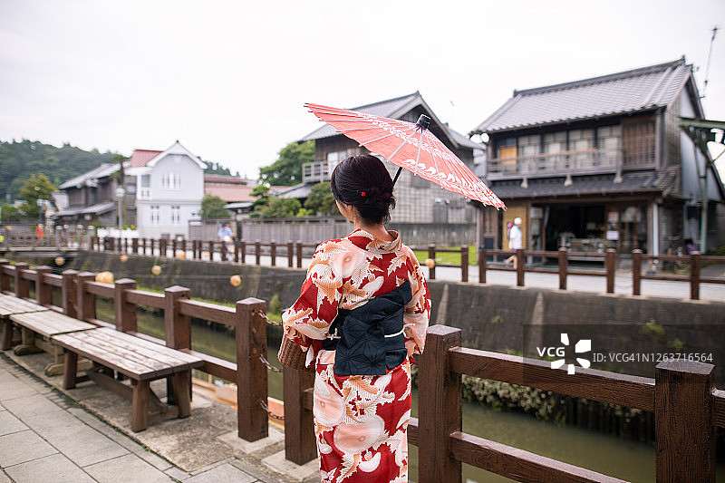 穿着日式浴衣在夏季的传统日本村庄观光的中年妇女图片素材