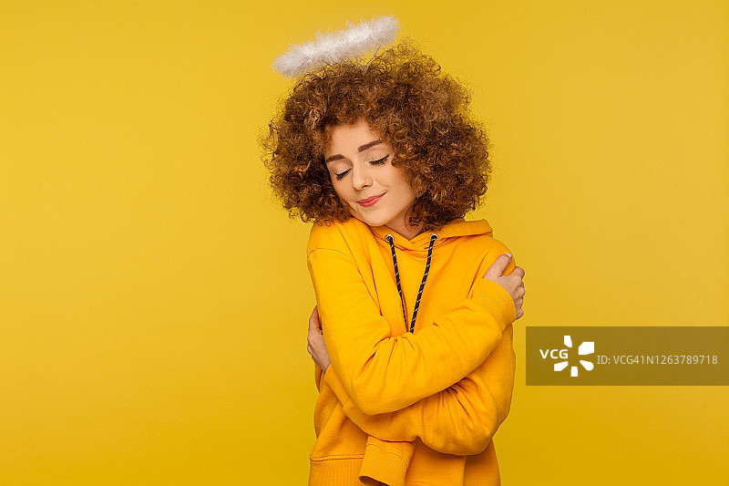 我爱自己！拥抱自己的卷发美丽天使女人肖像图片素材