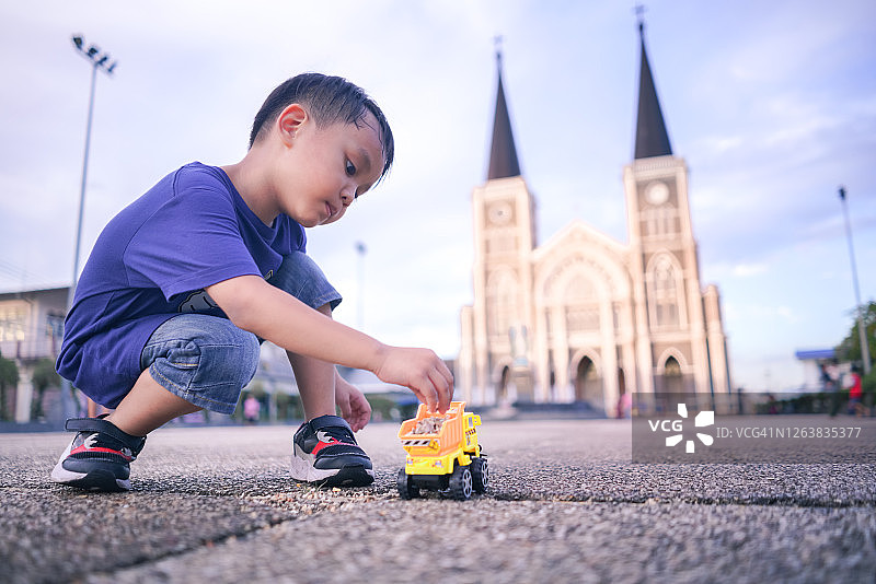 小朋友在尖竹汶府罗马天主教堂前玩玩具卡车图片素材