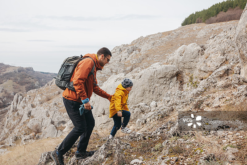 父子在岩石山上徒步旅行图片素材