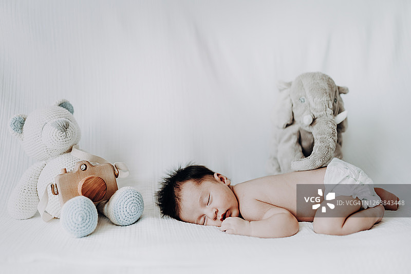 和好朋友一起在床上睡觉的男婴图片素材