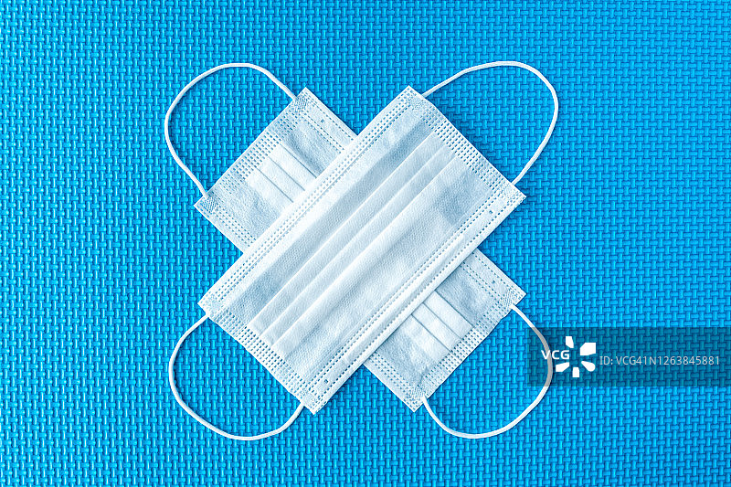 蓝色背景上的外科流感/冠状病毒口罩图片素材