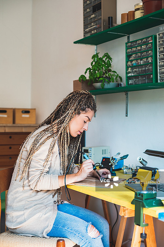女工程师在硬件维修店维修电子设备图片素材
