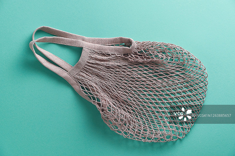 可重复使用的环保购物袋，由可回收材料制成的网兜，绿色背景图片素材