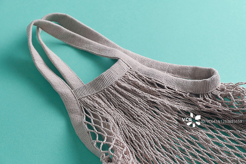 可重复使用的环保购物袋，由可回收材料制成的网兜，绿色背景图片素材