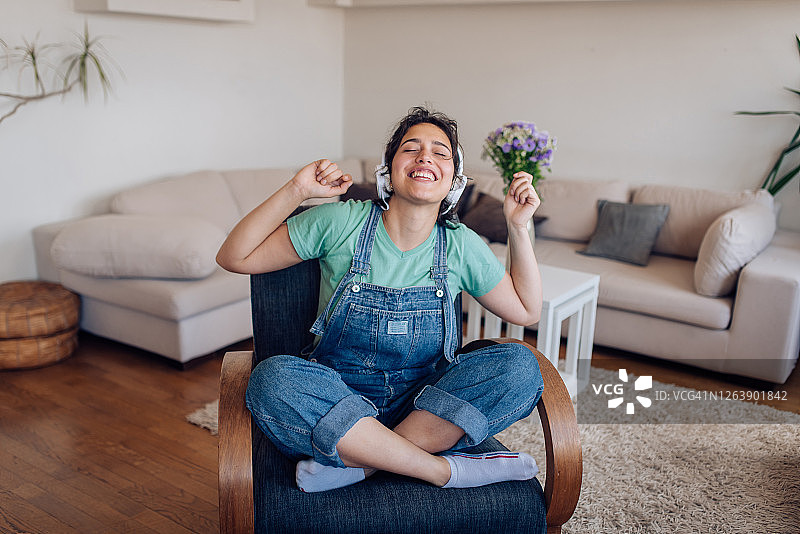 年轻女人在家享受她最喜欢的音乐图片素材